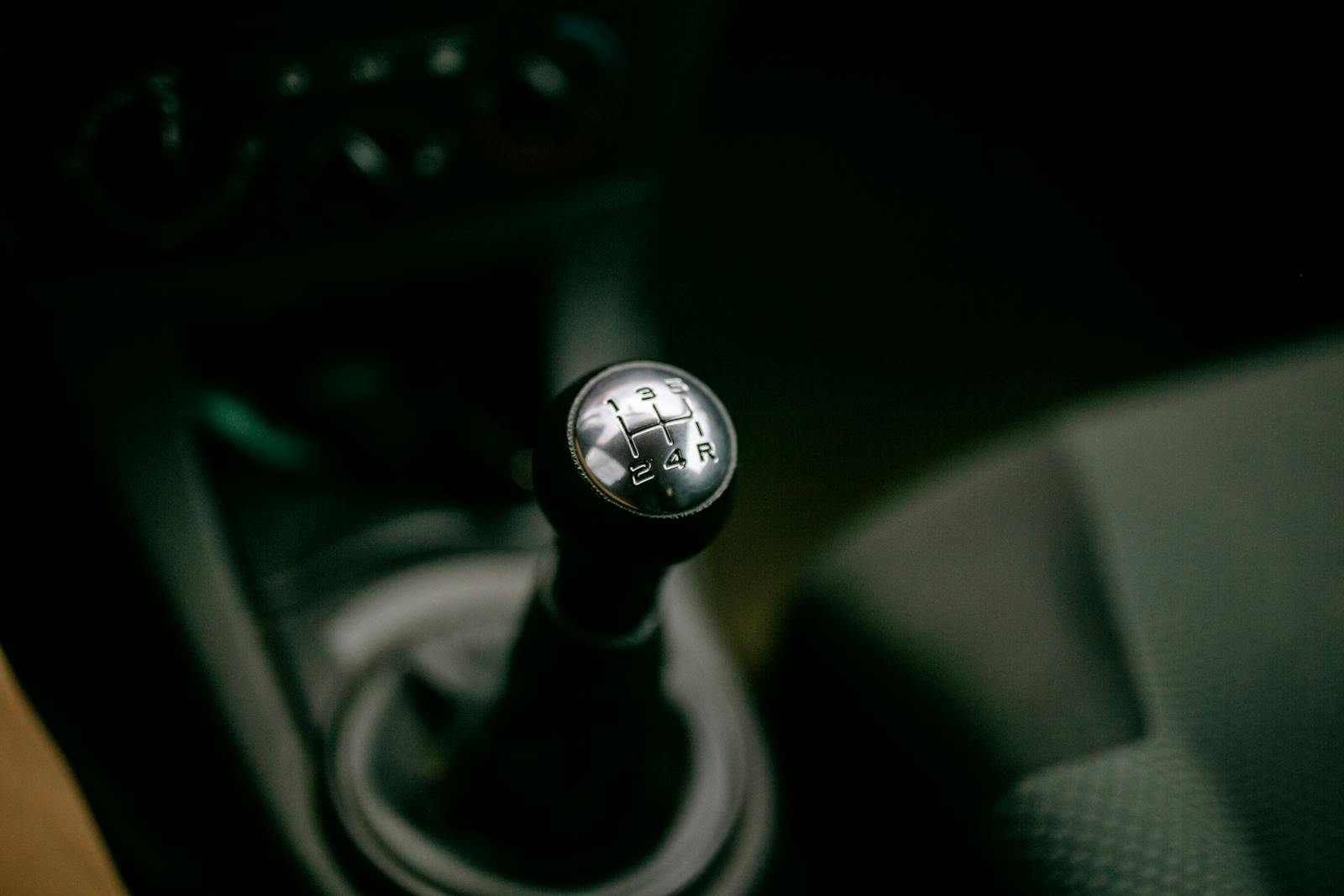 Detailed view of a manual gear shifter inside a vehicle, with a focus on the gear shift knob.