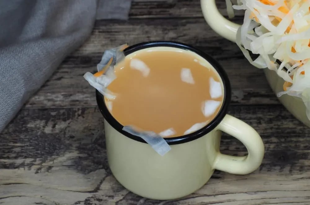 Šolja sa sokom od turšije i turšija u pozadini.