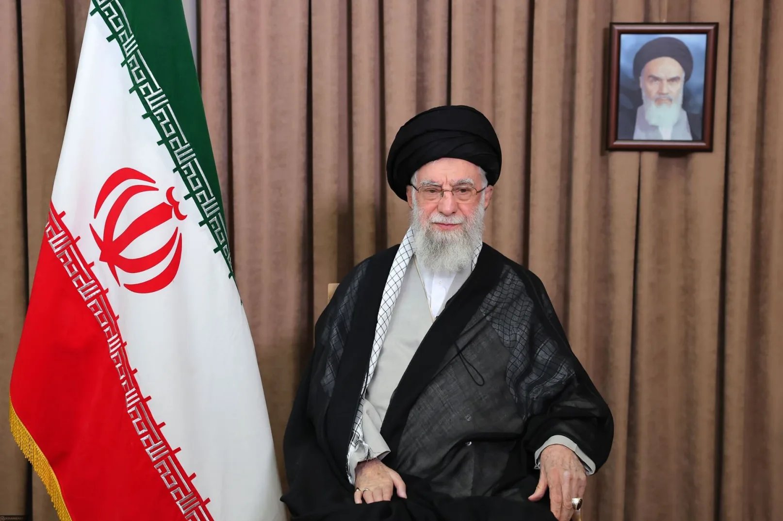 Ali Khamenei, ajatolah i vrhovni vođa Irana, pozira pored zastave Irana.