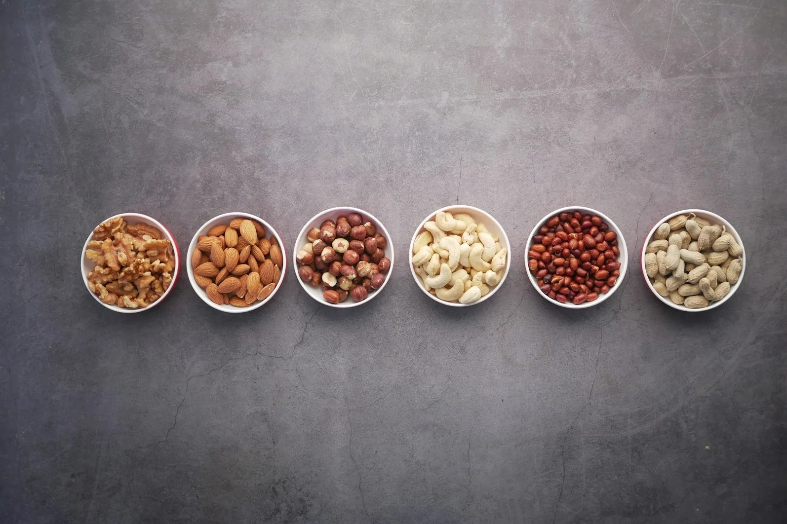 Različite vrste orašastih plodova poredane u zdjelicama.