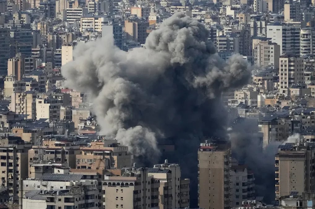 Ogroman stub gustog sivog dima izdiže se iznad gusto izgrađenog gradskog područja.