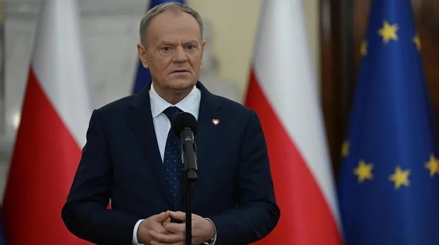 Donald Tusk stoji pred zastavama Poljske i Evropske unije.
