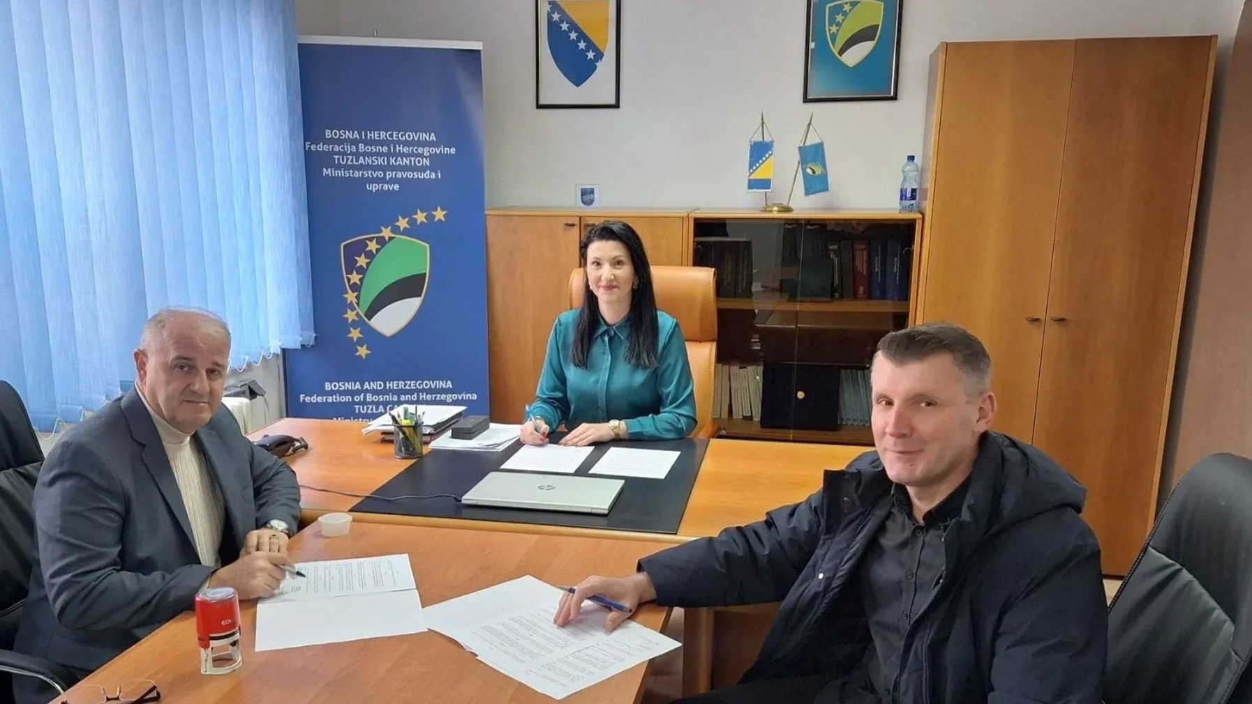 Tri osobe sjede za stolom u kancelariji Ministarstva pravosuđa Tuzlanskog kantona