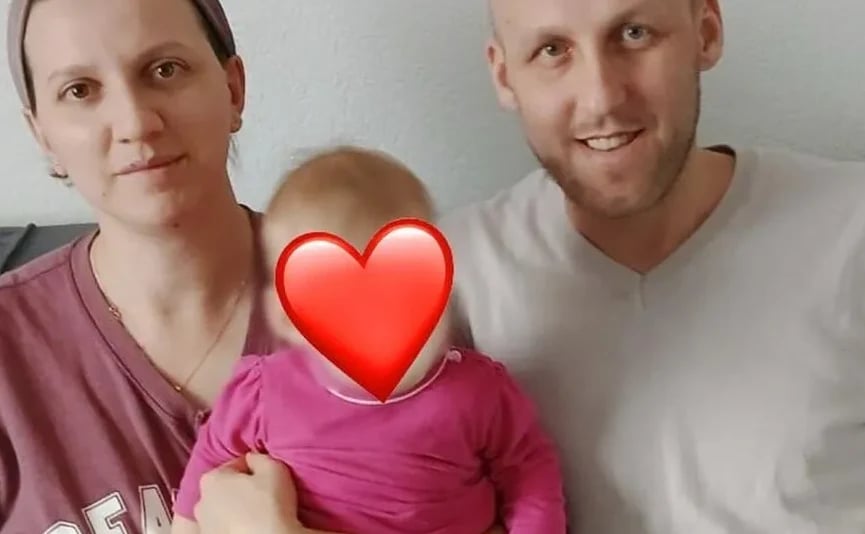 Sretna mlada porodica sa bebom u naručju.