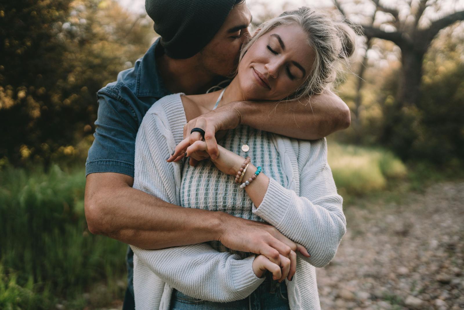 A couple shares a loving embrace outdoors, expressing emotion and connection.