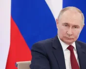 Portret Vladimira Putina ispred ruske zastave.