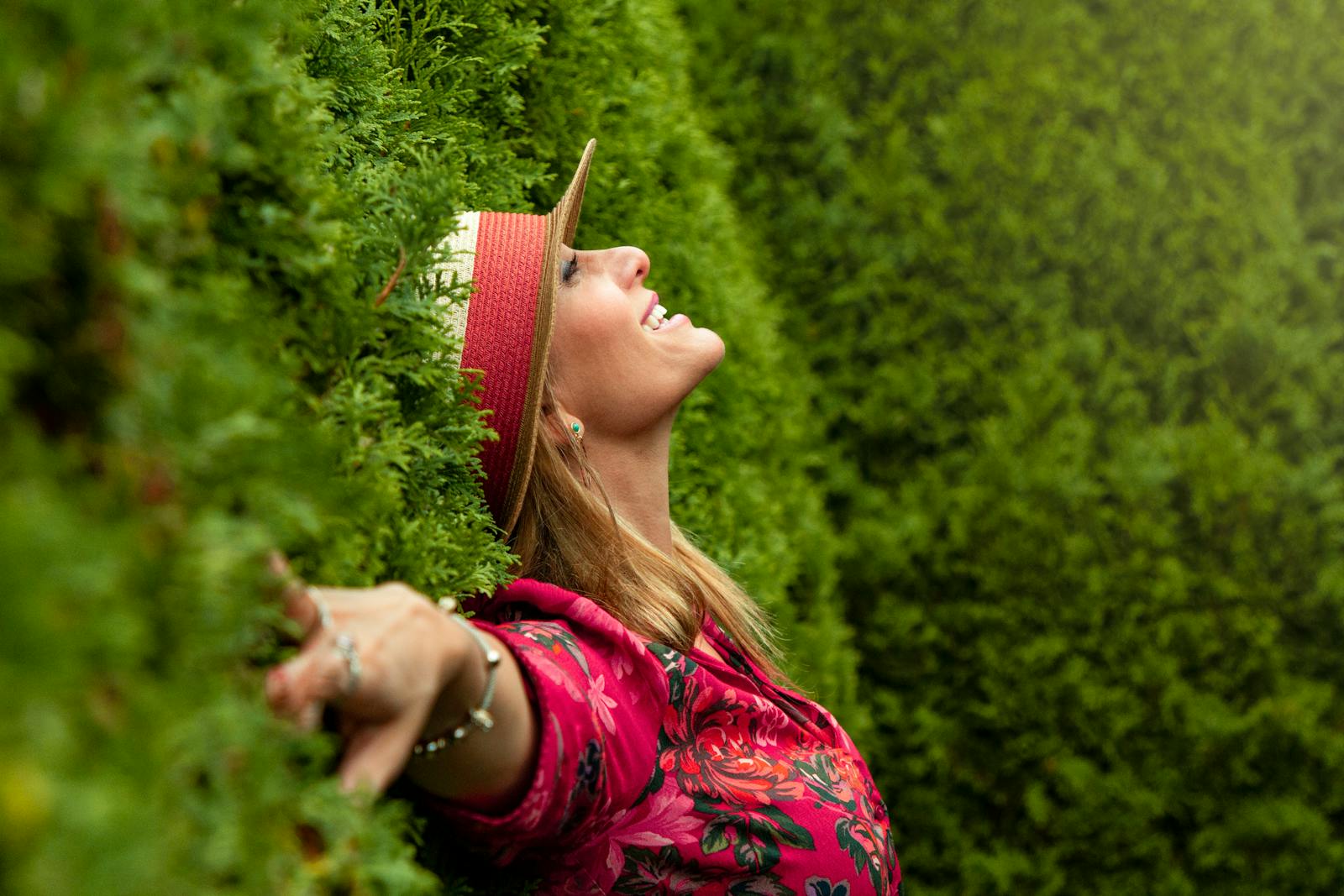 A joyful woman enjoying nature, embracing freedom in a lush green park.