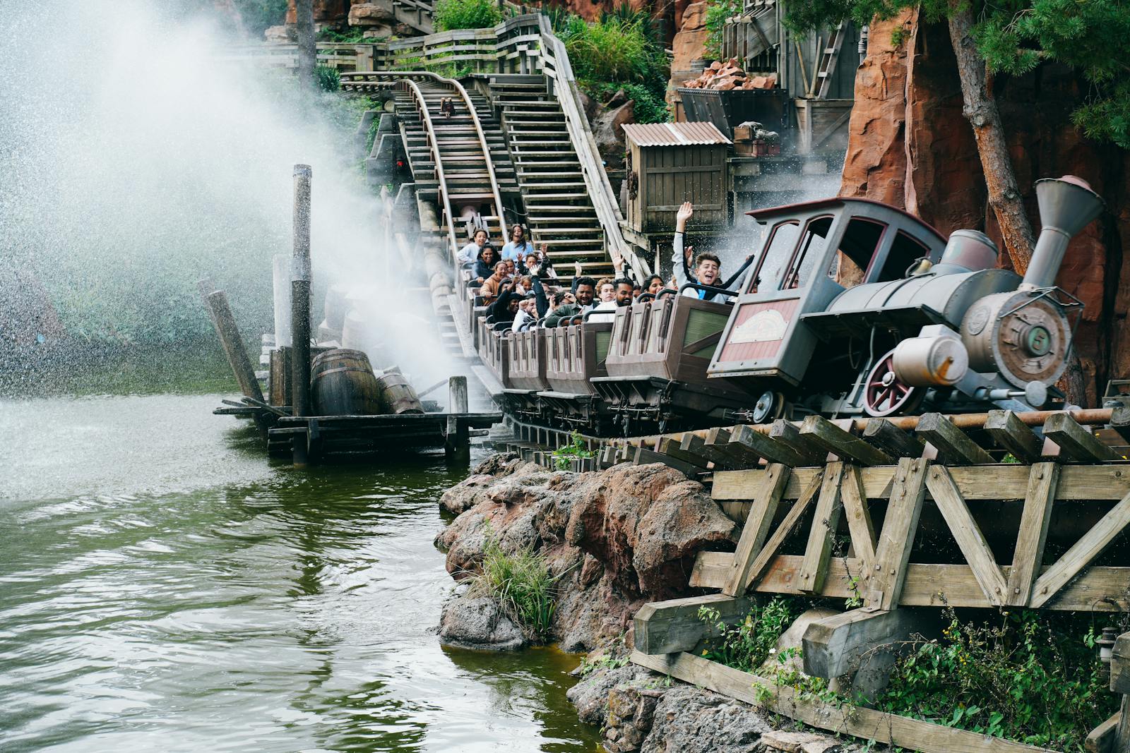 Thrilling ride on Big Thunder Mountain Railroad at Disneyland Paris with splashing water and excited visitors.