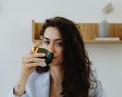 Close-up of a woman savoring a beverage, creating a cozy atmosphere.
