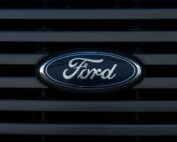 Detailed view of a Ford emblem mounted on a vehicle grille, showcasing modern design.