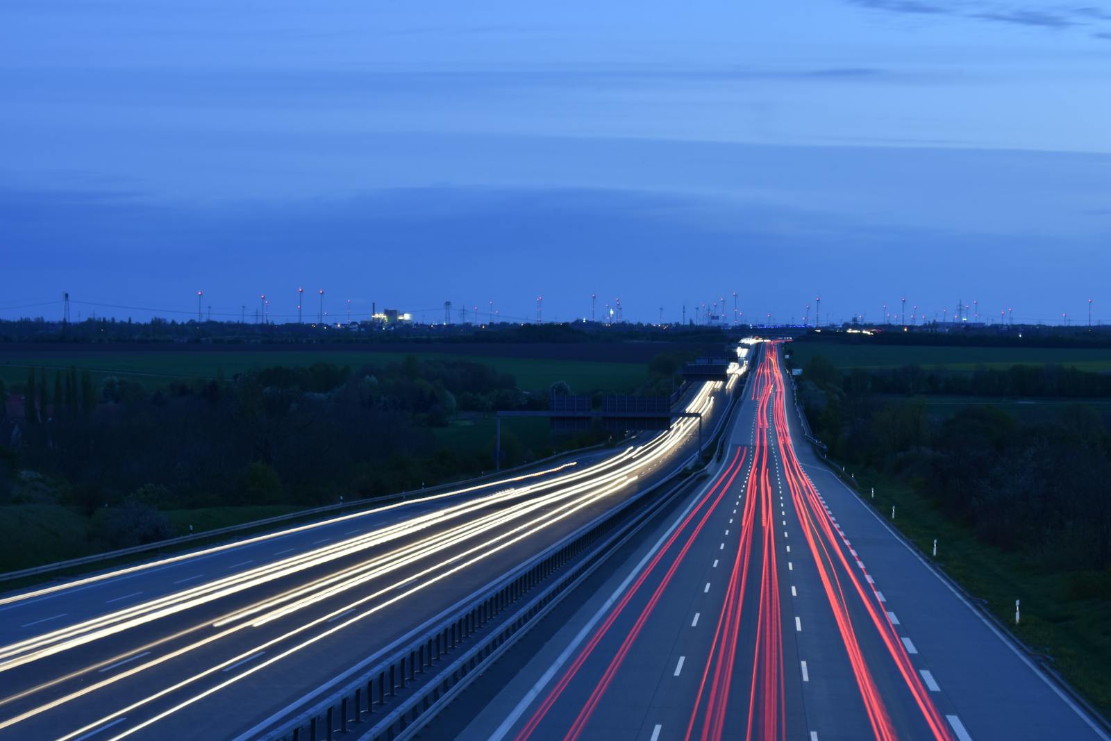 Dramatic long exposure of highway traffic at night near Lützen, Germany, showcasing light trails and serene landscape.
