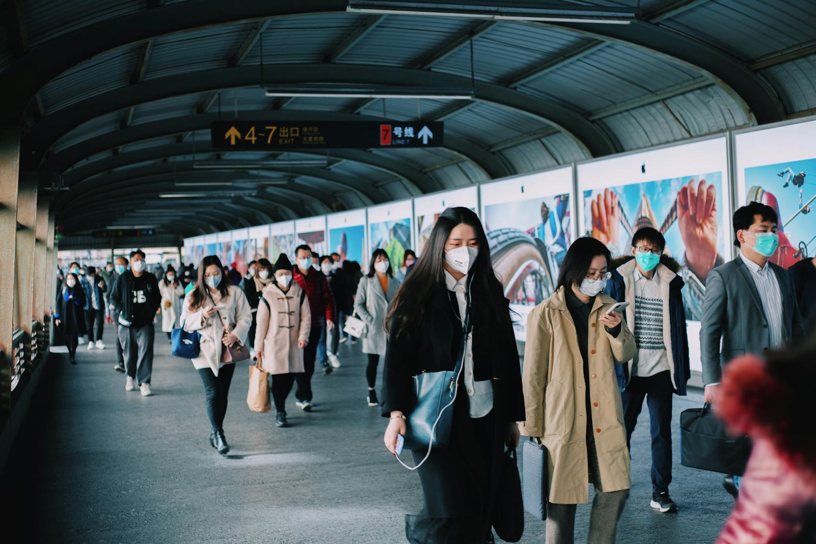Masked commuters walking through a subway station in Shanghai, China, reflecting pandemic life.