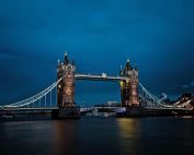A stunning view of the illuminated Tower Bridge in London against a deep blue night sky.