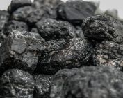 Detailed image of dark, textured coal pieces in a close-up view, highlighting their rugged surface.
