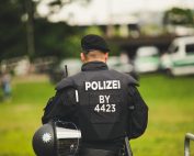 A police officer stands in uniform outdoors, highlighting law enforcement.