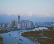 Stunning dusk view of Ho Chi Minh City skyline reflecting on the Saigon River's calm waters.