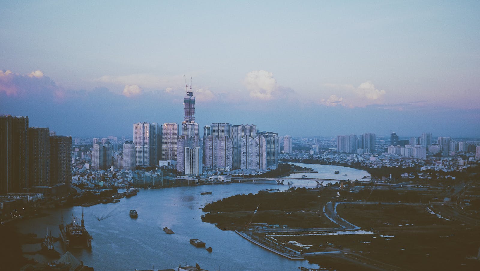 Stunning dusk view of Ho Chi Minh City skyline reflecting on the Saigon River's calm waters.
