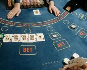 A casino gaming table featuring poker cards and chips, showcasing a vibrant gambling scene.