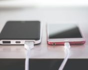Two smartphones charging side by side on a desk. Modern and technological setting.