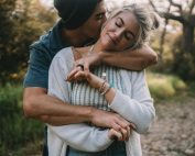A couple shares a loving embrace outdoors, expressing emotion and connection.