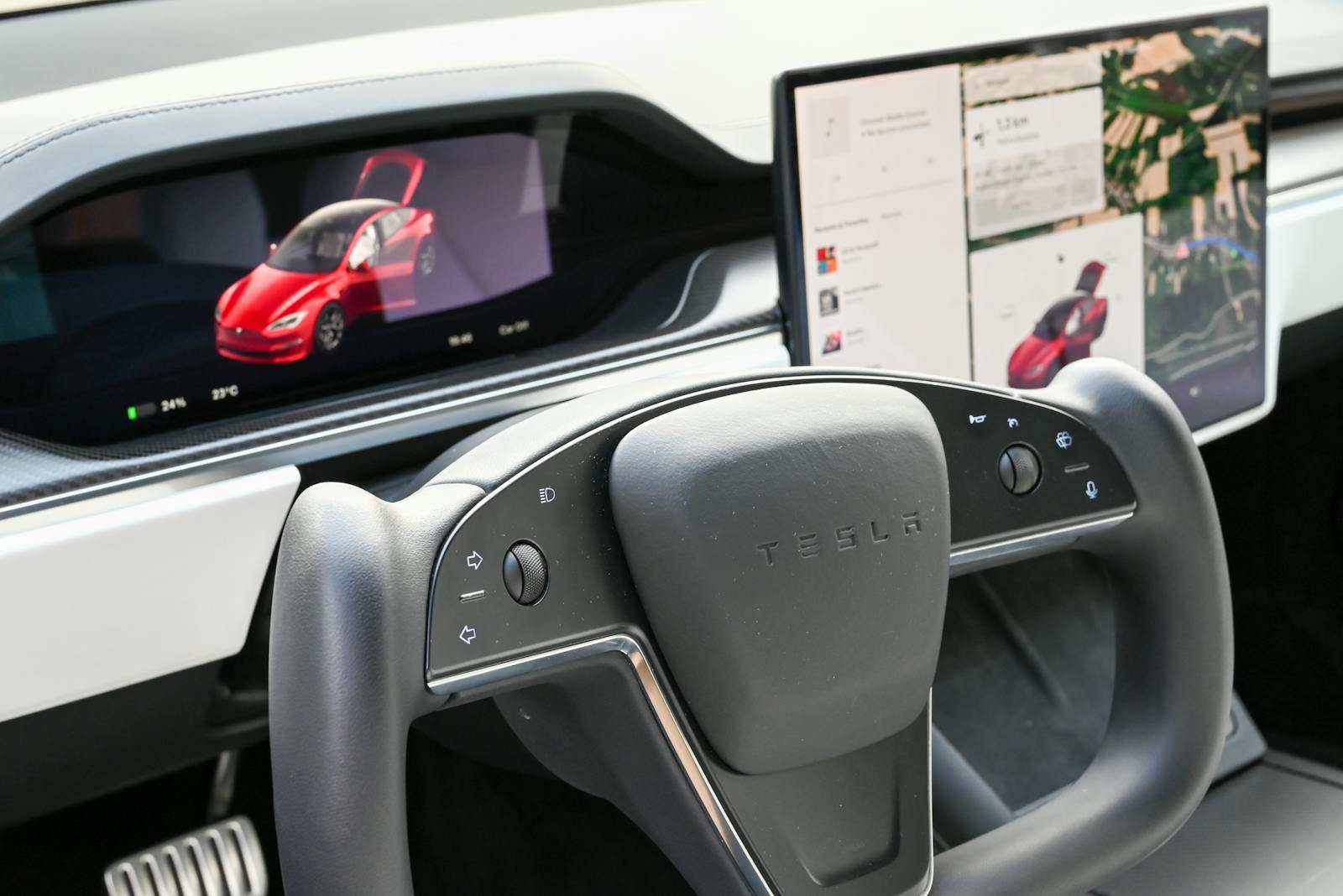 Premium Tesla dashboard featuring dual screens and innovative steering wheel design.