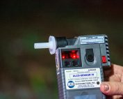 Detailed close-up of Alco-Sensor IV breathalyzer device held by a person outdoors in Londrina, Brazil.