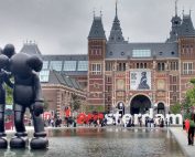 The Rijksmuseum facade with modern art sculptures and reflection in Amsterdam.