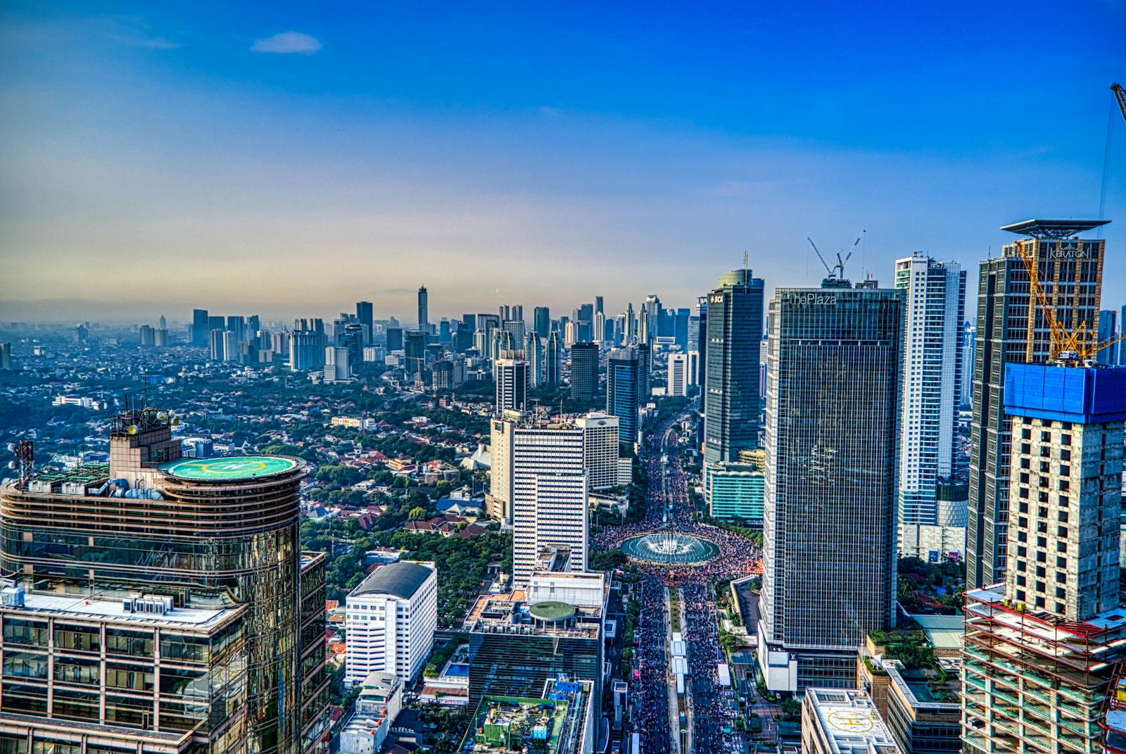 A breathtaking aerial view of Jakarta's urban skyline during the day, showcasing skyscrapers and city life.