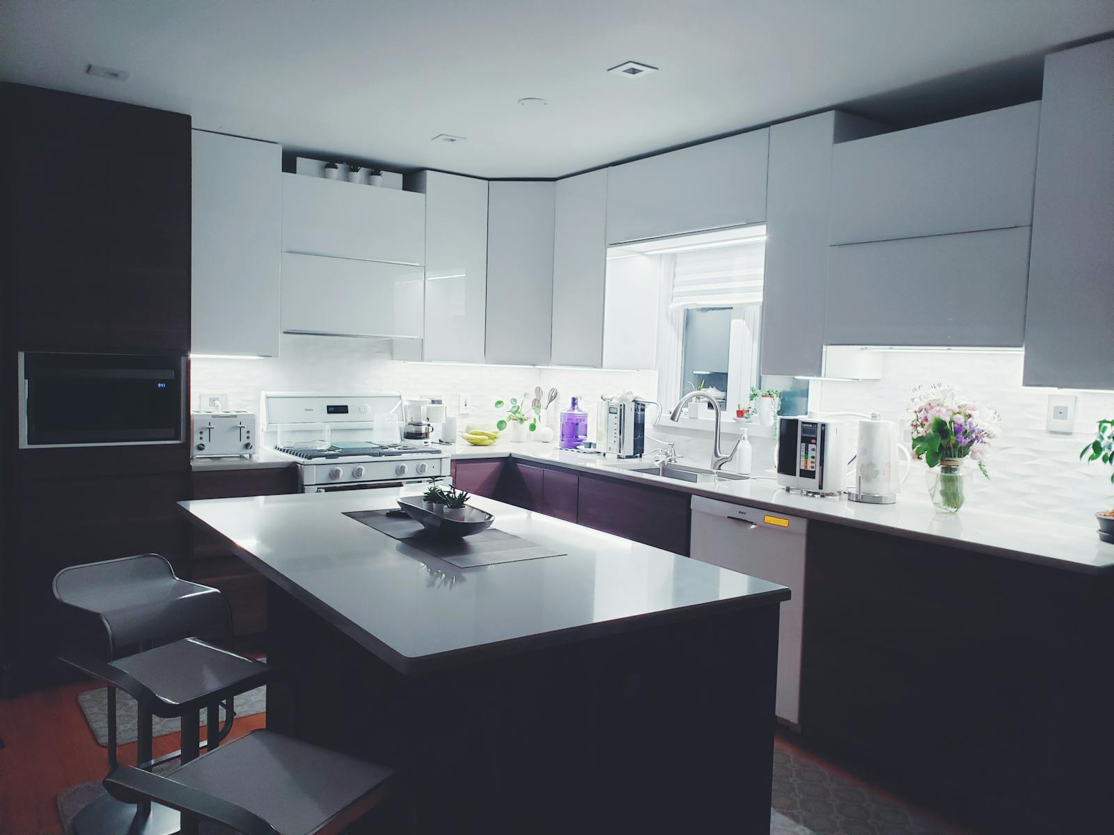 Contemporary kitchen interior with sleek white cabinets and island, perfect for a minimalist aesthetic.