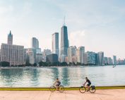 Cyclists biking along the Chicago waterfront with a stunning skyline view.