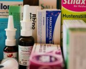 Assortment of cold and flu medications on a pharmacy counter.