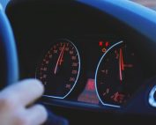 A detailed view of a car's speedometer and dashboard, emphasizing speed and technology.