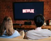 A couple enjoys a relaxed evening watching Netflix in their living room.