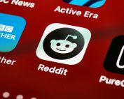 Detailed view of the Reddit app icon on a smartphone screen displaying popular applications.