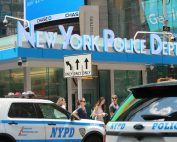 NYPD cars and people in front of New York Police Department building in Times Square.
