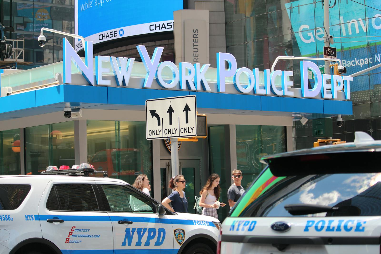 NYPD cars and people in front of New York Police Department building in Times Square.