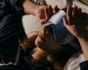 A woman resting at home wearing a sleep mask for a cozy afternoon nap.