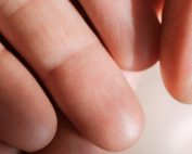Detailed close-up of human fingers showing skin texture and fingerprints.