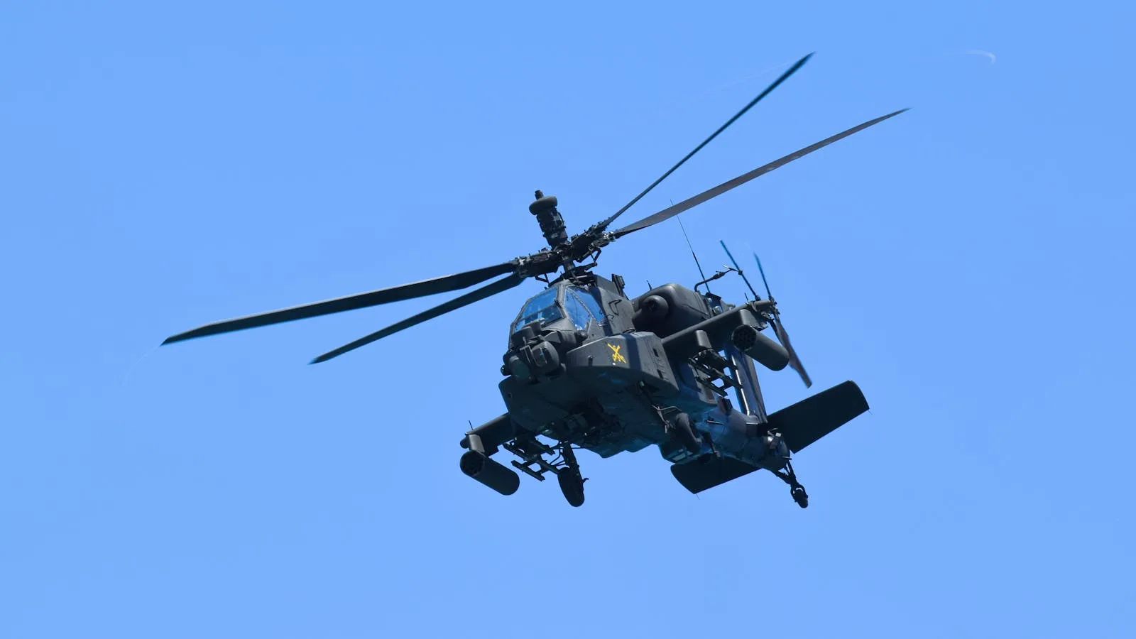 Američki borbeni helikopter Apache u letu na plavom nebu