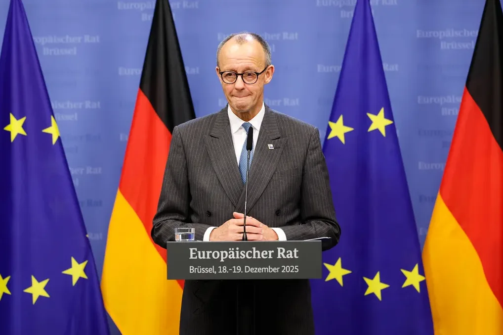 Friedrich Merz na konferenciji za novinare u Briselu ispred zastava EU i Njemačke.