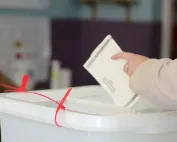 Glasanje: Ruka ubacuje glasački listić u kutiju.