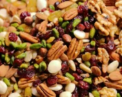 Detaljan prikaz mješavine orašastih plodova i suhog voća, uključujući bademe, orahe, pistacije i brusnice.