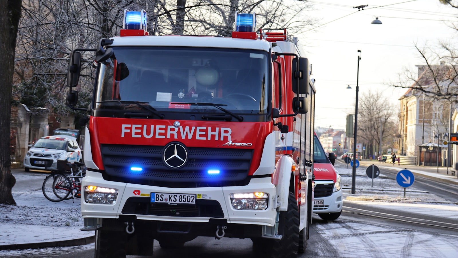 a red and white truck driving down a street