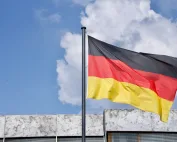 Njemacka zastava vijori se na jarbolu pod plavim nebom.