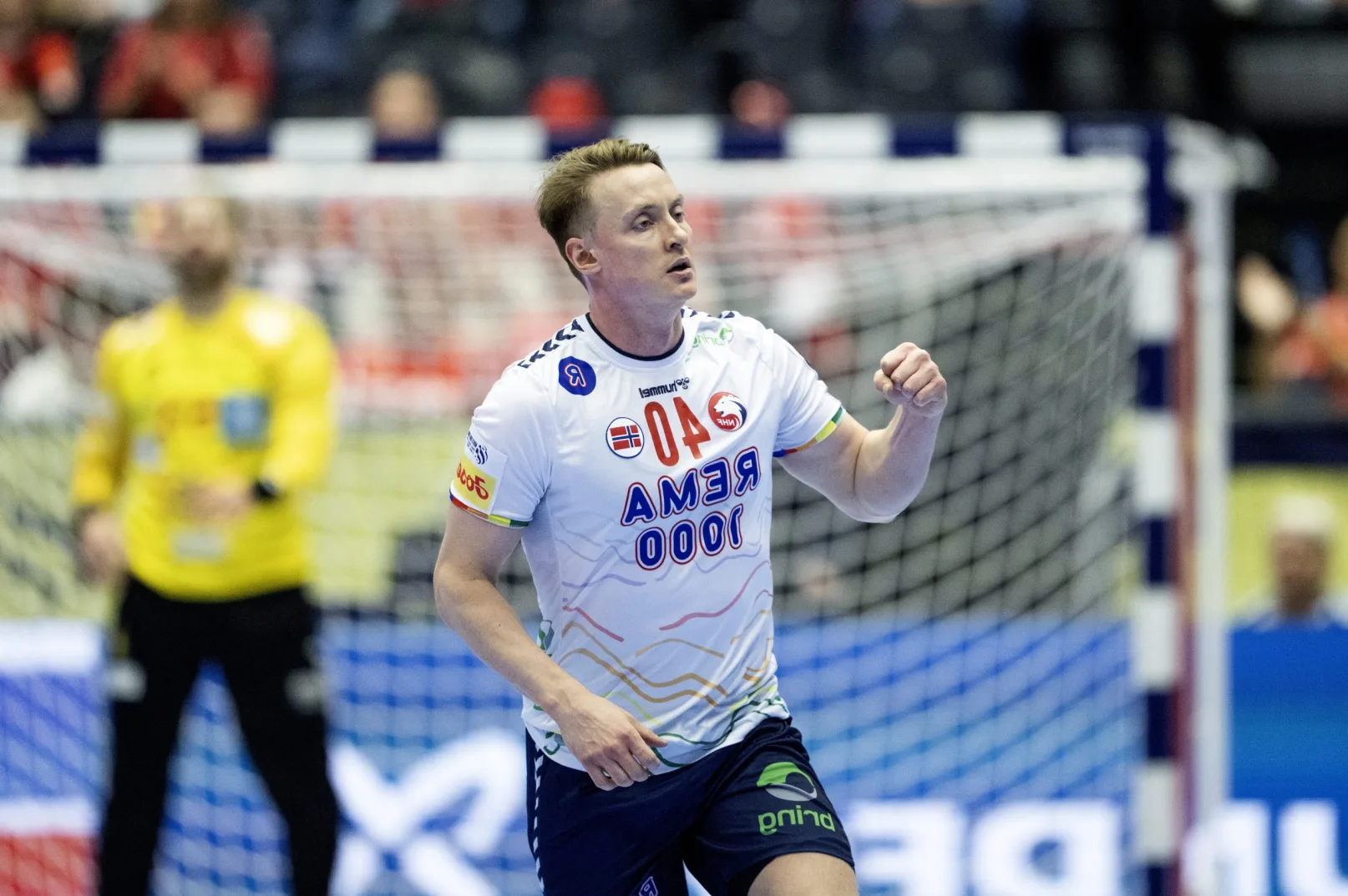 Rukometaš Norveške reprezentacije slavi postignuti gol, noseći dres sa natpisom REMA 1000.