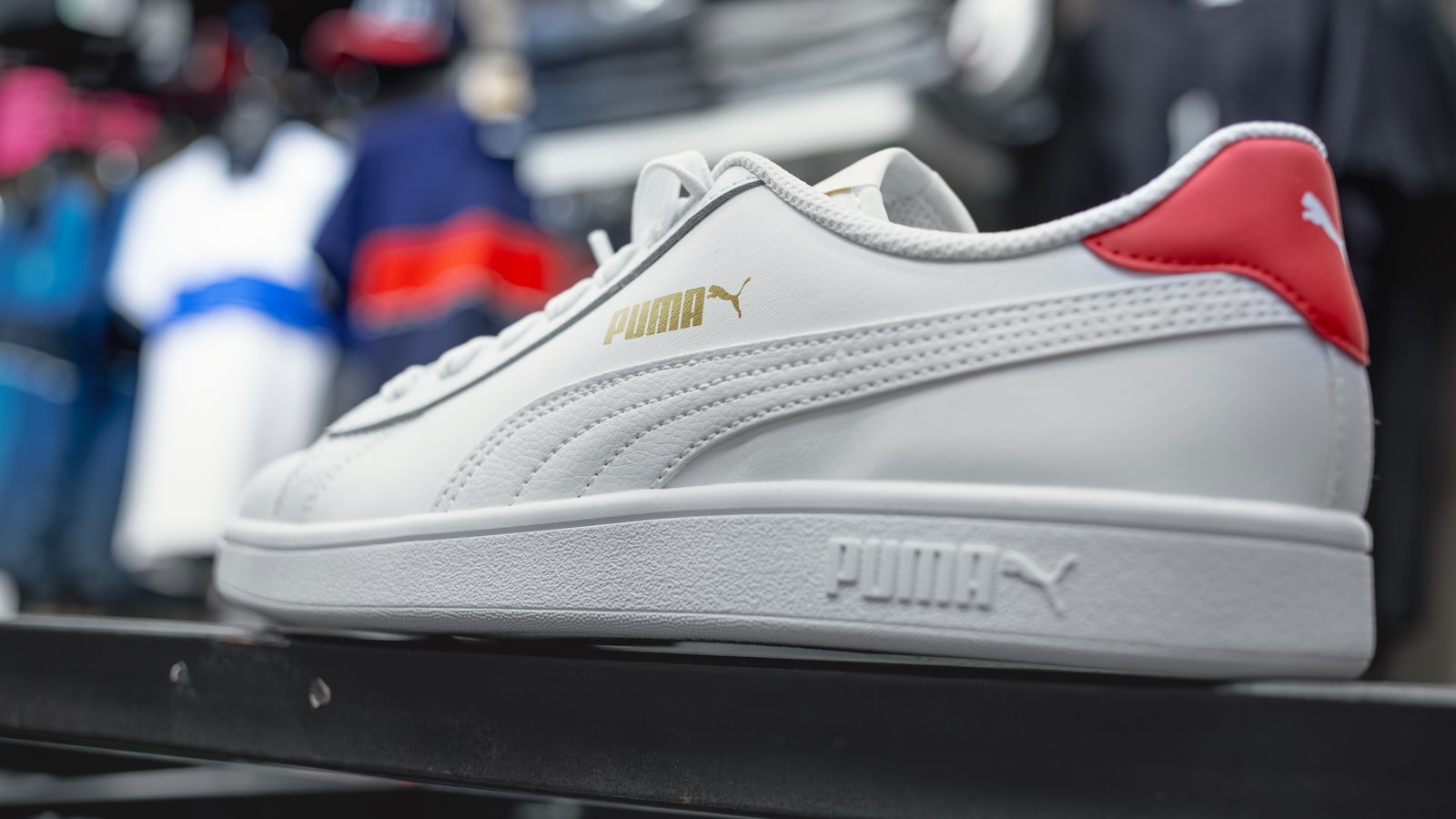 a white and red sneaker sitting on top of a shelf