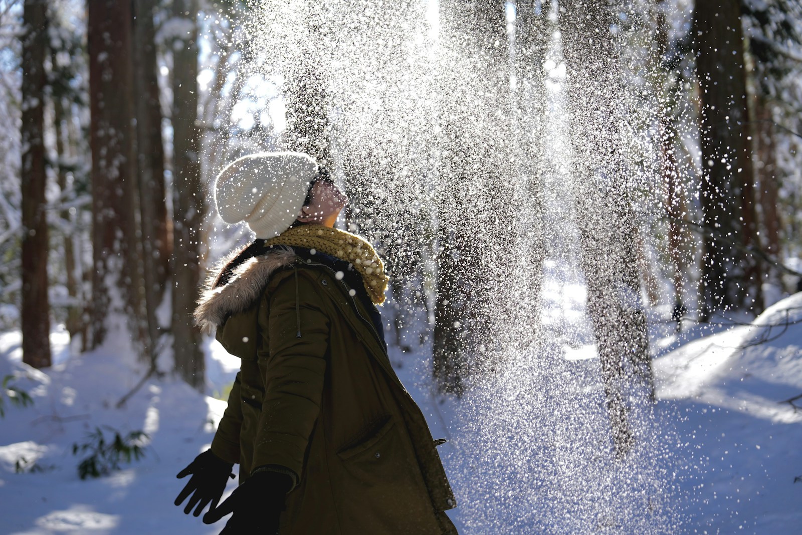 A woman walking through a snow covered forest