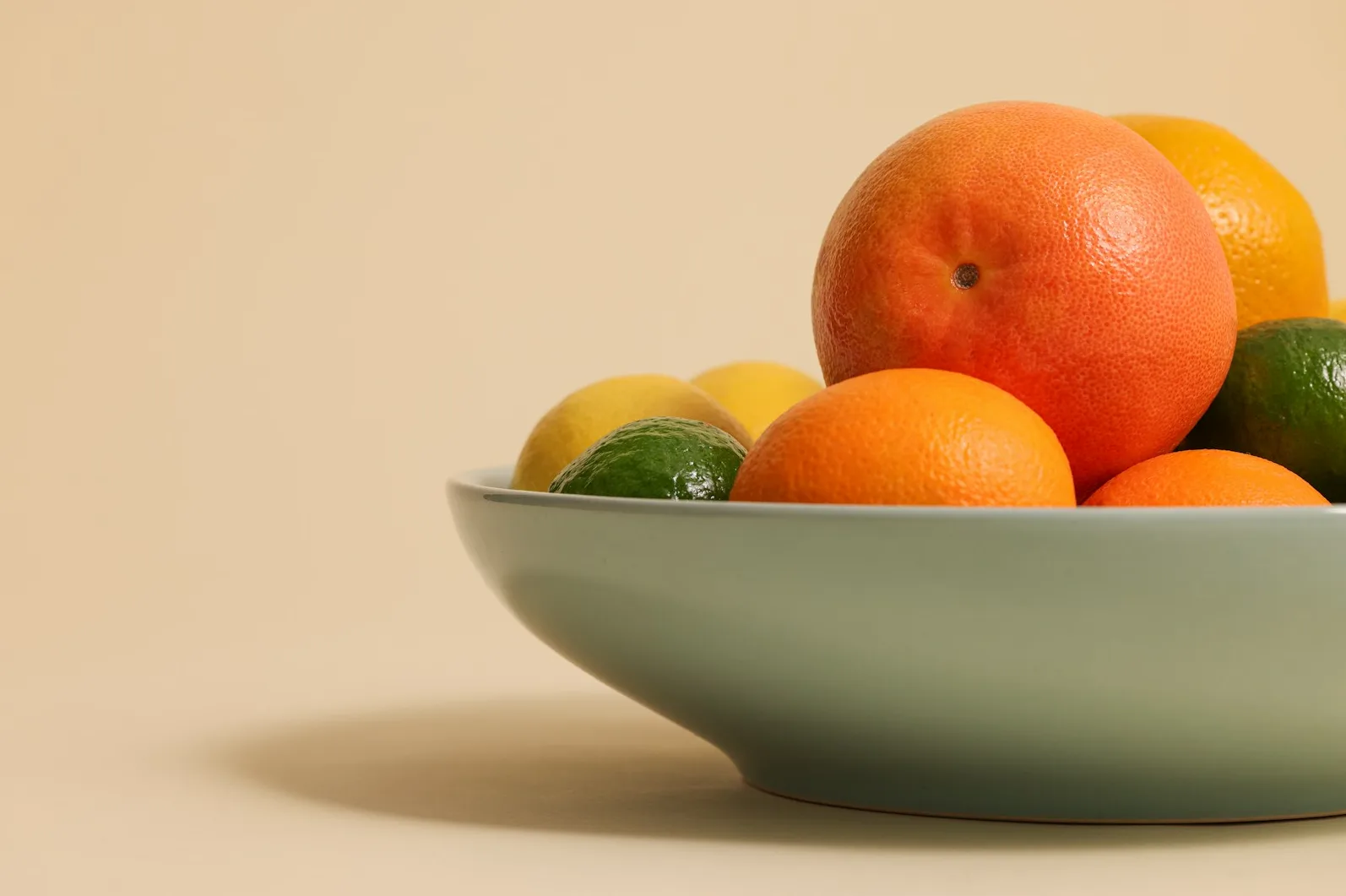 Zdjela puna raznovrsnog citrusnog voća, uključujući grejp, narandže, limune i limete.