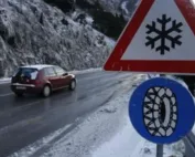 Automobil vozi zimskim putem pored znaka za obaveznu zimsku opremu i opasnost od poledice.