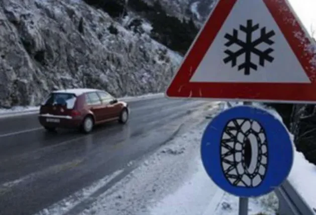 Automobil vozi zimskim putem pored znaka za obaveznu zimsku opremu i opasnost od poledice.